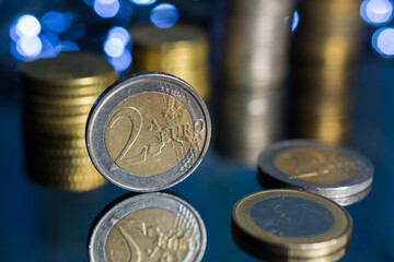 Euro coins and many coins stacked on top of each other.