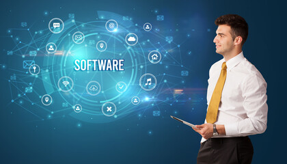 Businessman thinking in front of technology related icons and SOFTWARE inscription, modern technology concept