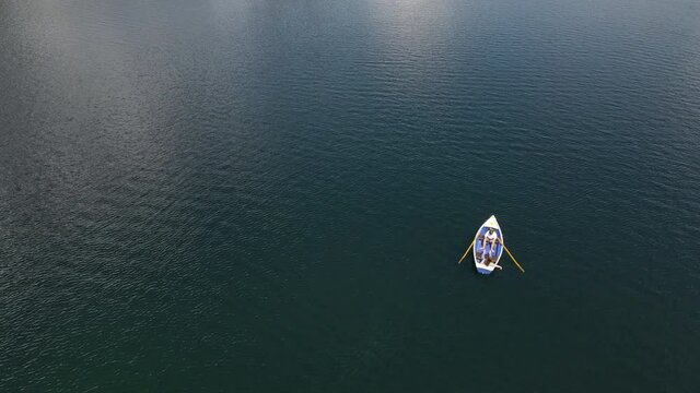 Couple on a rowboat shipping over a lake, Eibsee, aerial drone shot, nature, lovers, vertical jib, movement upwards