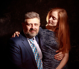 Bearded man and young woman, happy couple studio portrait