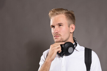 Young man dressed in white shirt and with headphones