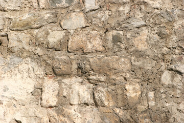Old beige stone wall texture background close up