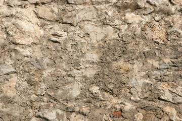 Old beige stone wall texture background close up