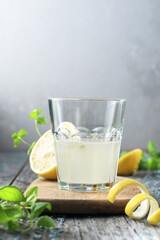 Lemon juice in a glass on a wooden board with a space copy.