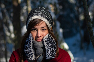 Christmas photoshoot of an European woman model with fashion clothing, scarf and gloves during holidays with snowfall