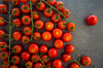 Fototapeta na wymiar A lot of cherry tomatoes on a table. Grey background. Top view photo of fresh vegetables. 