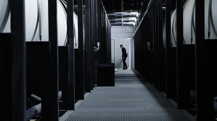 Man in suit walks along industrial corridor. Media. Man in business suit checks work of industrial production. Business man walks along new industrial corridor - Powered by Adobe