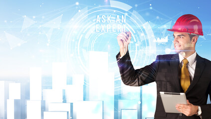 Handsome businessman with helmet drawing ASK AN EXPERT inscription, contruction business concept
