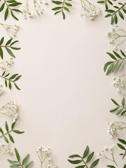 Frame of white flowers and green leaves