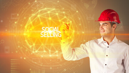 Handsome businessman with helmet drawing SOCIAL SELLING inscription, social construction concept