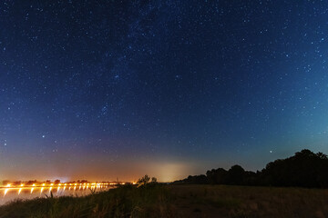 Naklejka na ściany i meble A magical starry night on the river by the Milky Way and a comet in the sky