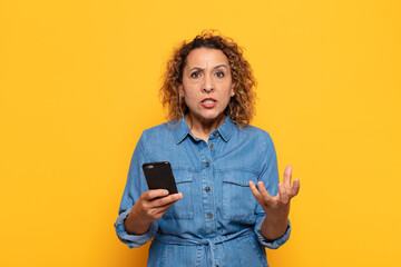 hispanic middle age woman looking angry, annoyed and frustrated screaming wtf or what’s wrong...