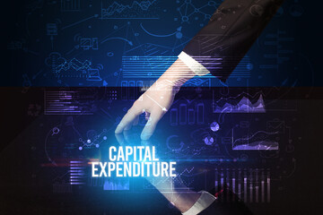 Businessman touching huge screen with CAPITAL EXPENDITURE inscription, cyber business concept