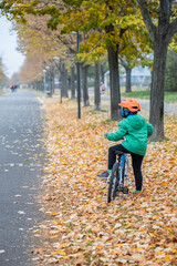 Beautiful autumn shot of a child on a bike looking at something
