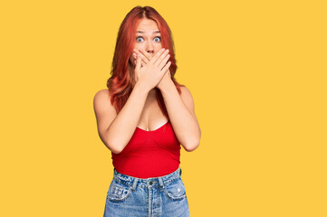 Young redhead woman wearing casual clothes shocked covering mouth with hands for mistake. secret concept.