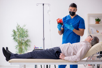 Old patient visiting young male doctor for intravenous therapy
