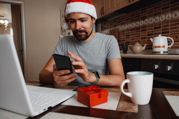 A hipster man with a red cup sitting at home at Christmas time.