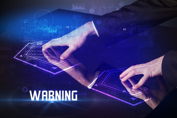 Hand touching digital table with WARNING inscription, new age security concept