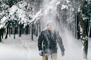 Happy smiling man under tha falling snow