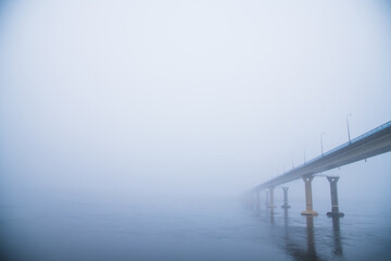 Bridge over the river in heavy fog