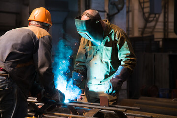 Welders working at the factory made metal