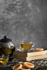 Relaxing tea time concept. Dark mood view of herbal tea and cookies