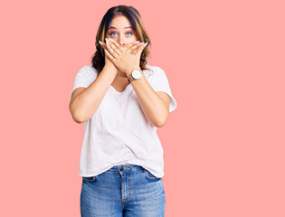 Young beautiful caucasian woman wearing casual white tshirt shocked covering mouth with hands for mistake. secret concept.