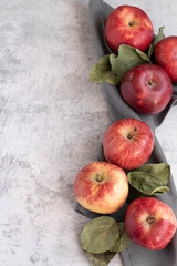 Ripe red apples on grey background, space for text