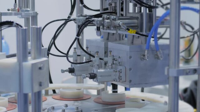 Automatic vacuum capping machine during work in demonstration mode at packaging exhibition, trade show - close up view. Manufacturing, industry, automated technology equipment concept
