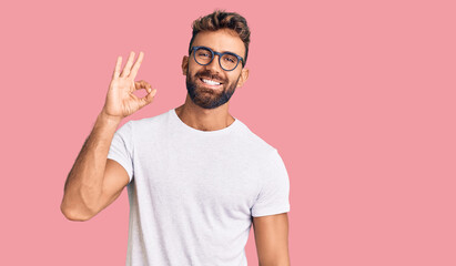 Young hispanic man wearing casual clothes and glasses smiling positive doing ok sign with hand and fingers. successful expression. - Powered by Adobe
