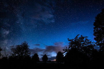 Fototapeta premium Overhead milky way with stars in clear summer night. Old barn house. Country side.