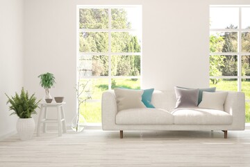 White living room with sofa and summer landscape in window. Scandinavian interior design. 3D illustration