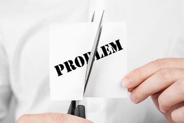 Man cuts scissors sticker with text Problem