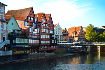 Fototapeta na wymiar View of the embankment of Ilmenau river with old historical houses in traditional German architecture style. Luneburg city, Germany.