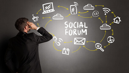 businessman drawing social media icons with SOCIAL FORUM inscription, new media concept