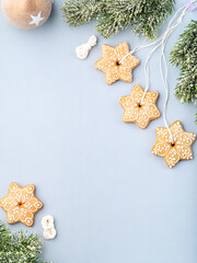 Simple Christmas or New Year background with gingerbread cookies shaped as a snowflakes, fir tree and decoration. Copy space for text. Christmas, New Year and winter holidays concept.