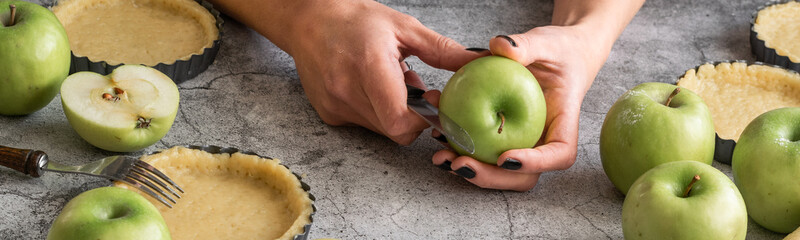 Close up of woman hands preparing sweet pie with apples