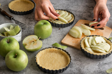 Close up of woman hands preparing sweet pie with apples