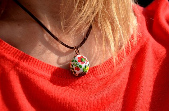 Floral pattern ball pendant Necklace with red poppy flowers on young woman's neck. Hand painted bright wooden jewelry