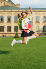 Energetic child in formal uniform with study books backpack jump in schoolyard happy celebrating, back to school