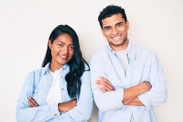 Beautiful latin young couple wearing casual clothes happy face smiling with crossed arms looking at...