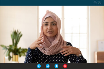 Close up computer screen web camera view beautiful young indian arabic businesswoman involved in video call conversation negotiation or passing online job interview, distant communication concept.