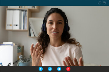 Head shot computer display view beautiful caucasian businesswoman in headphones talking holding...