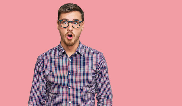 Handsome caucasian man wearing casual clothes and glasses afraid and shocked with surprise expression, fear and excited face.