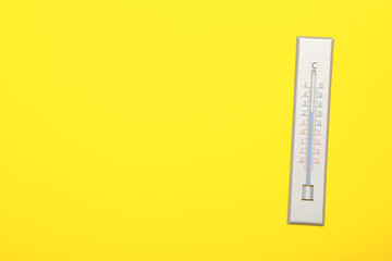 Weather thermometer on yellow background, top view. Space for text