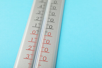 Weather thermometer on light blue background, closeup. Space for text