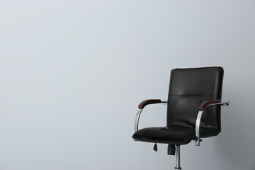 Comfortable office chair on light background. Space for text