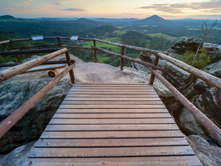 Wooden bridge to rocky viewpoint. Rocky tower in sandstone empire of national park.