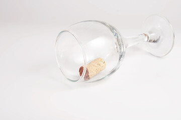 Wine cork in wine glass on white background