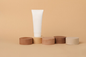Empty cosmetic tube standing on the geometrical podiums.Beautiful earth colors.Concept of the tonal foundation with different types of skin.Good for placing your product.